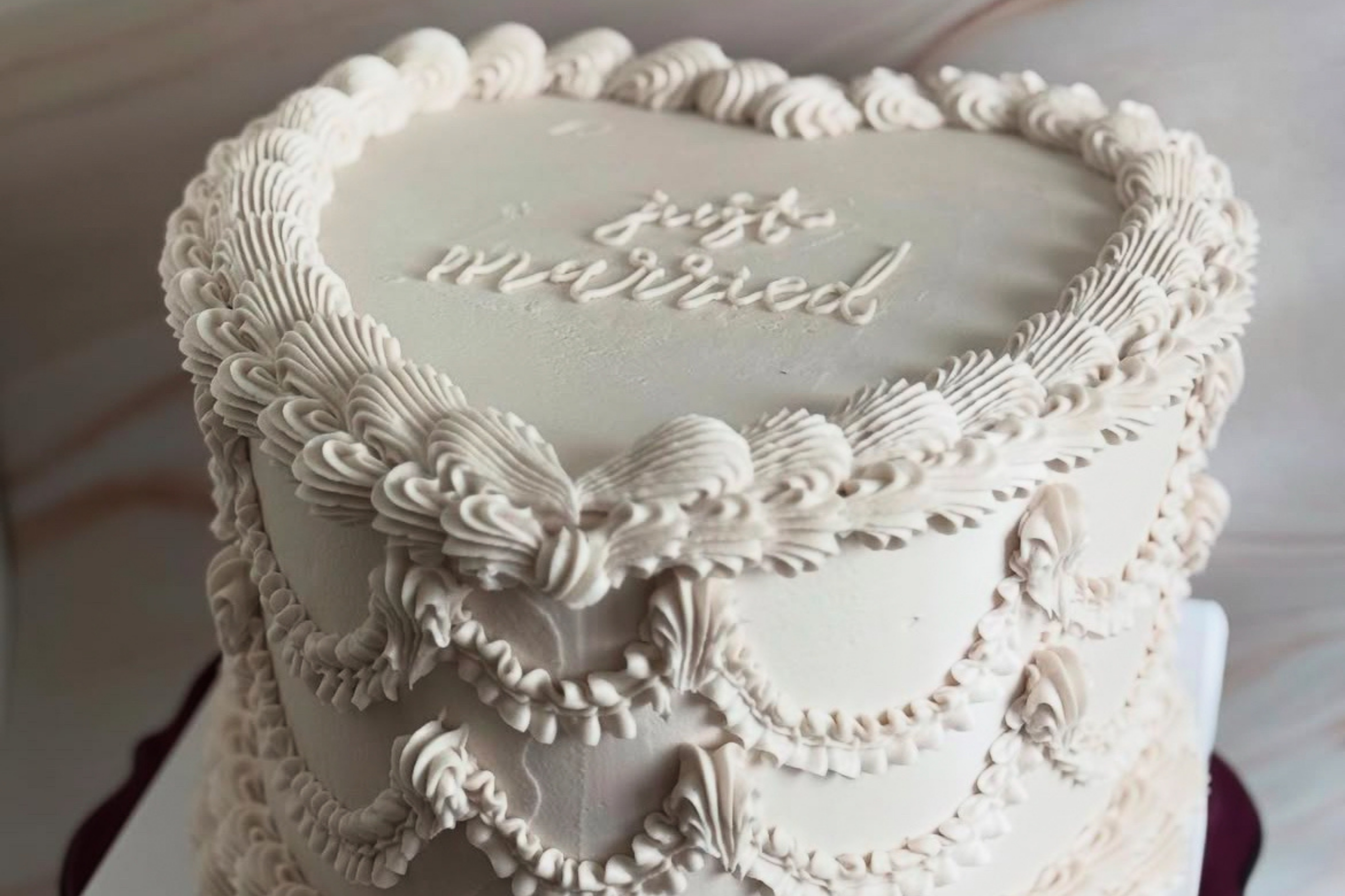 heart shaped white cake that reads "just married"