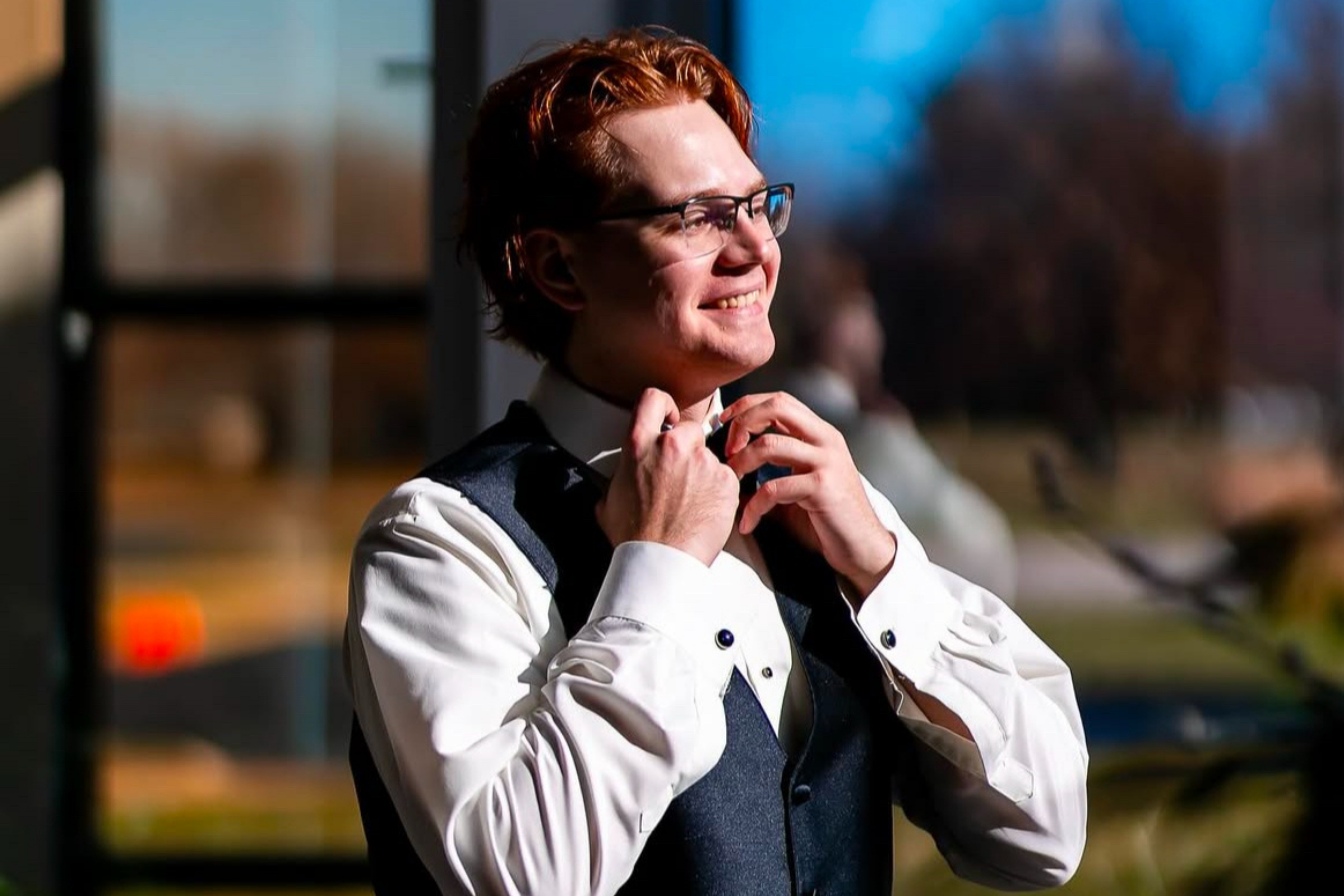 groom smiling, straightening his tie