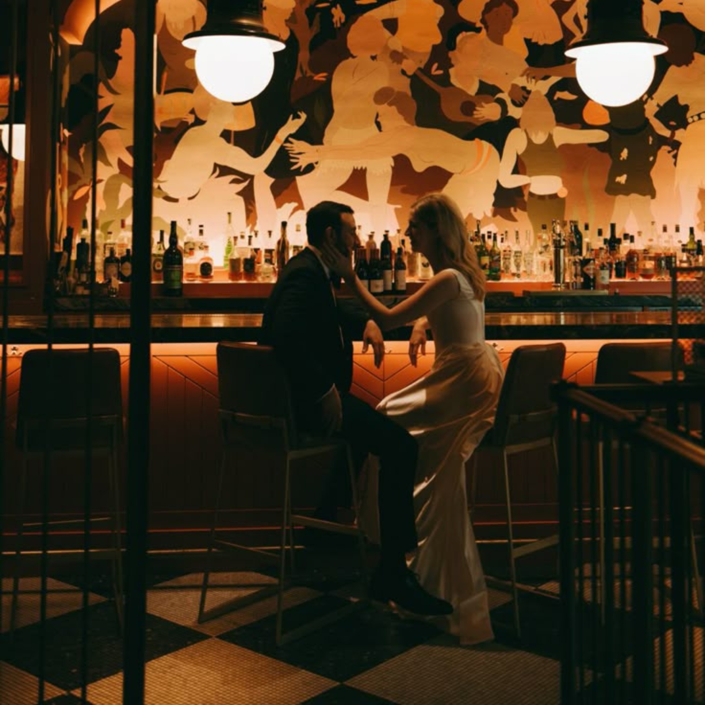bride and groom sitting at a bar