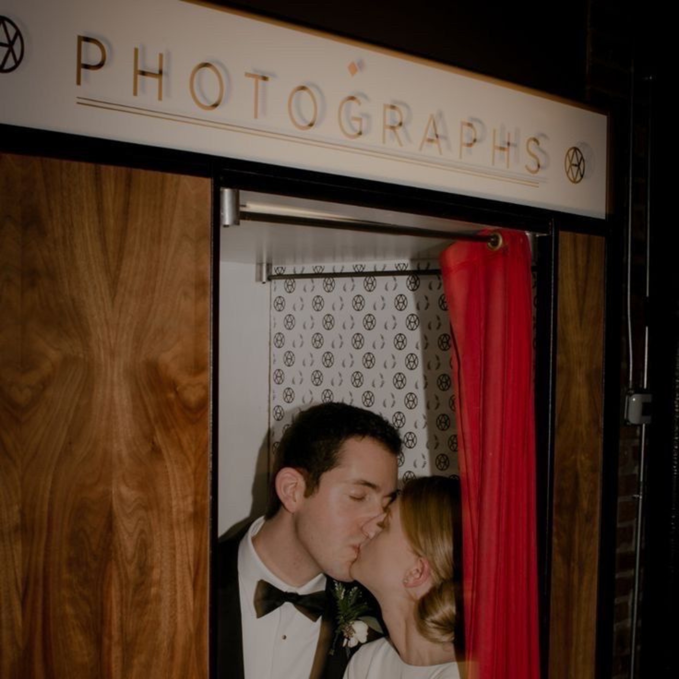 bride and groom kissing in a photobooth