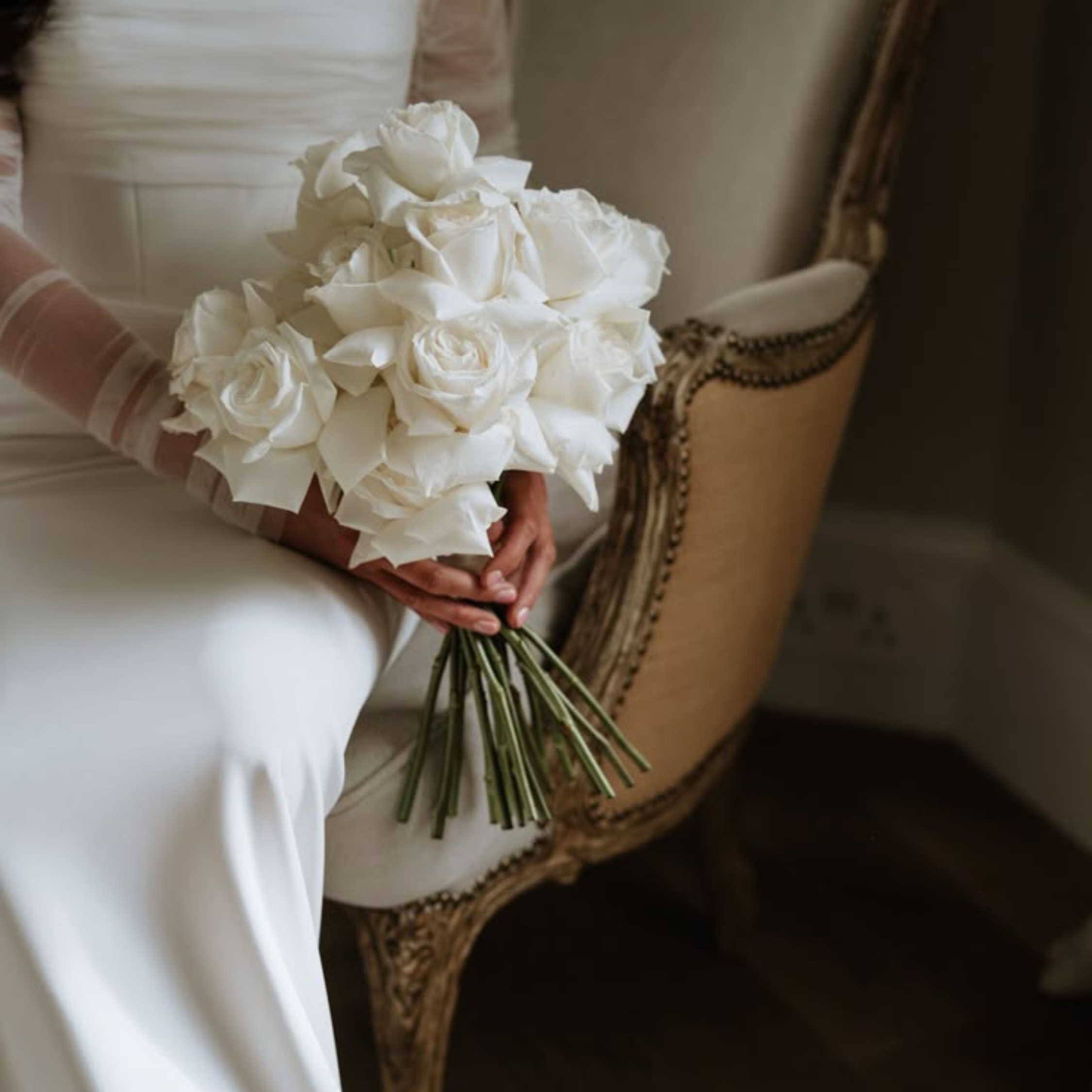 bride sitting in a chair holding a bouquet 