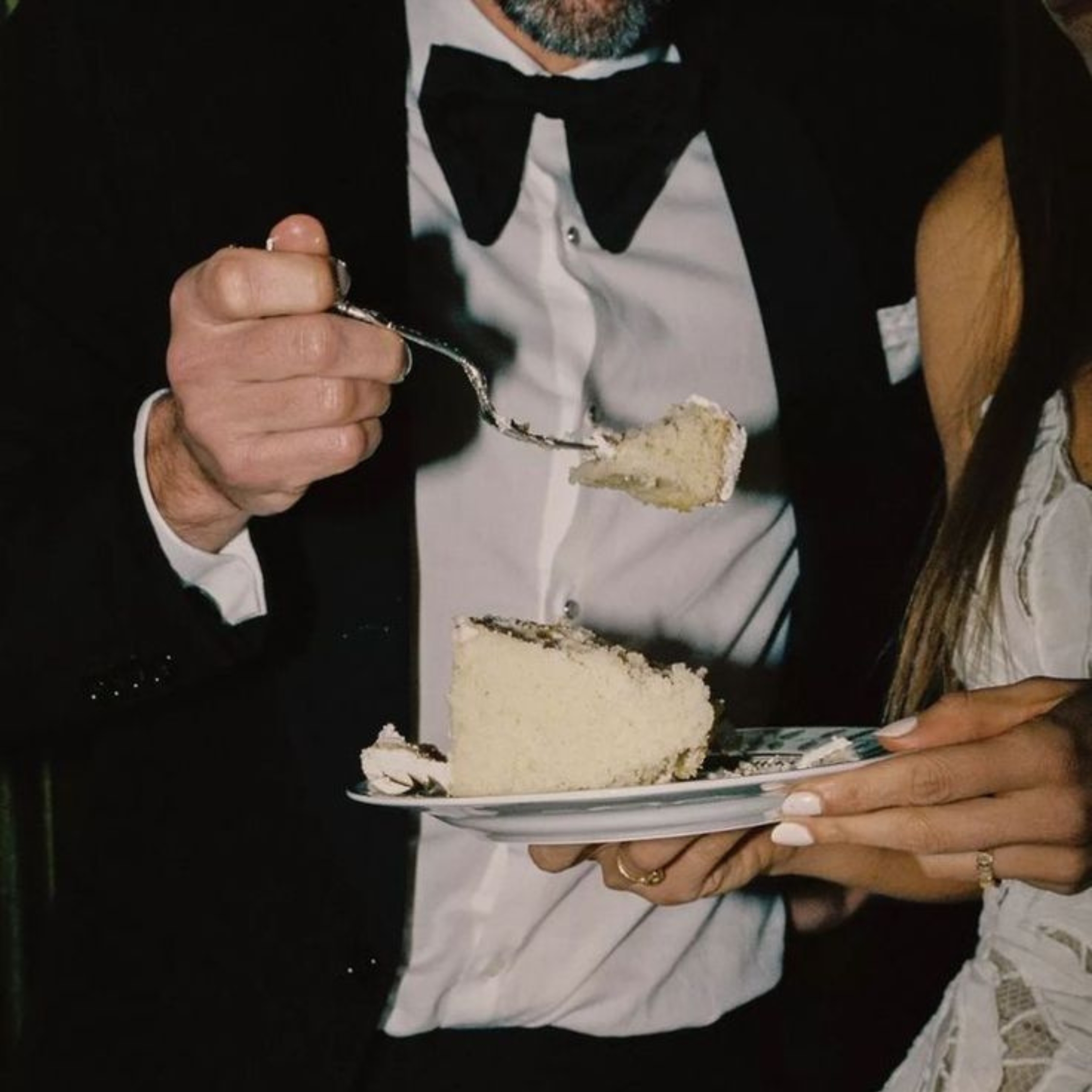 bride and groom holding a plate of cake