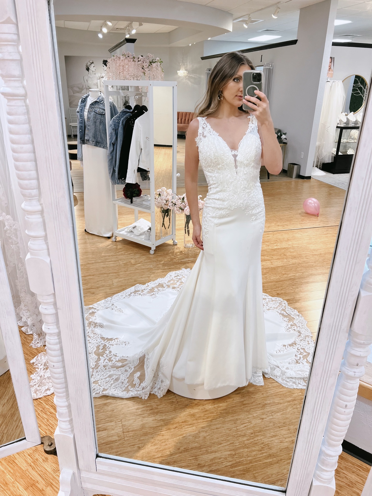 bride looking at the front of a dress in  mirror